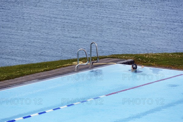 View from above of swimming pool by the sea, thermal bath, heated outdoor pool in Hofsos at the fjord Skagafjördur, Lake Greenland, Hofsos, Tröllaskagi peninsula, Nordurland vestra, North Iceland, Iceland