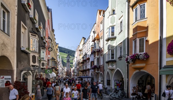 Old town, colourful houses in the main street, Zwölferturm tower at the back, old town, Sterzing, South Tyrol, Italy
