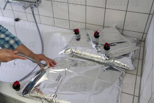 Filling a 10 litre water bag, for storing drinking water at home, as an emergency reserve in the event of a blackout or similar, lightweight, foldable, reusable bag made of multi-layer film, with dispensing device, for long-term storage of up to one year, recommended 3 litres of drinking water per person, for 10 days of storage