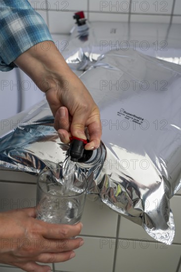 Tapping water from a 10 litre water bag, for storing drinking water at home, as an emergency reserve in the event of a blackout or similar, lightweight, foldable, reusable bag made of multi-layer film, with tapping device, for long-term storage of up to one year, recommended 3 litres of drinking water per person, for 10 days of storage