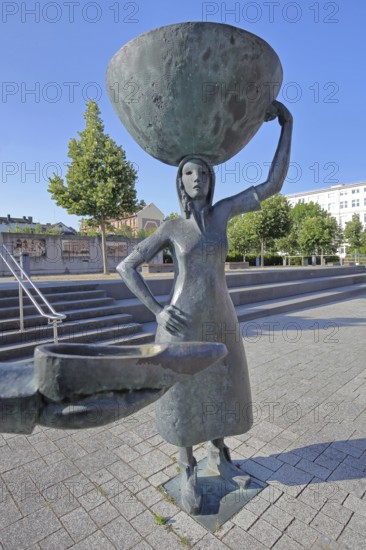 Sculpture Shoe Carrier by Martin Schöneich 2015, monument to woman during the development of the former shoe industry, shoe production, bronze sculpture, modern art, shoe, female figure, carrying a large basket on her head, symbol, shoemaker, carrier, presentation, show, Joseph-Krekeler-Platz, Alte Post, shoe carrier, Pirmasens, Rhineland-Palatinate, Germany