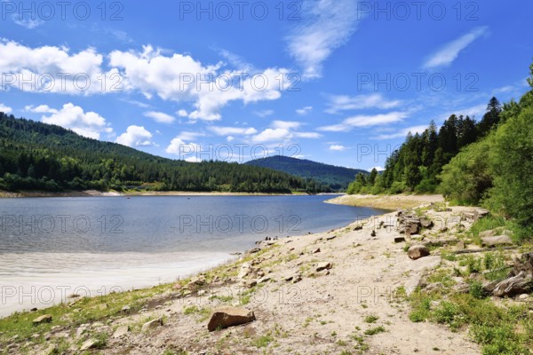Beautiful mountain lake in the Black Forest in Forbach in Germany called Schwarzenbach Reservoir surrounded by forested hills under a clear sky