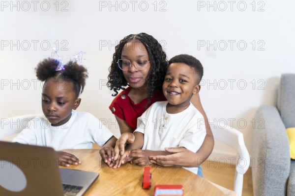 Mother and children using laptop for online education, homeschooling, working from home or watching a movie