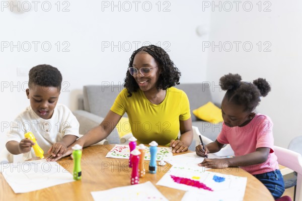 Mother and her two children enjoying creative time together, painting colorful pictures at home