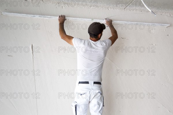 Plasterer smoothing and levelling interior walls