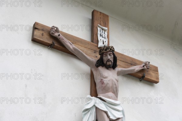 Wooden cross with a depiction of Jesus mounted on a white wall, Zgornje Jezersko, Gorenjska, Slovenia