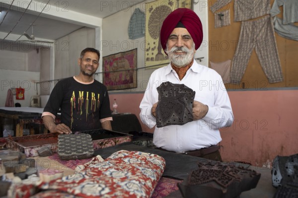 Indian men showing wooden panels for woodblock printing, Jaipur, Rajasthan, India