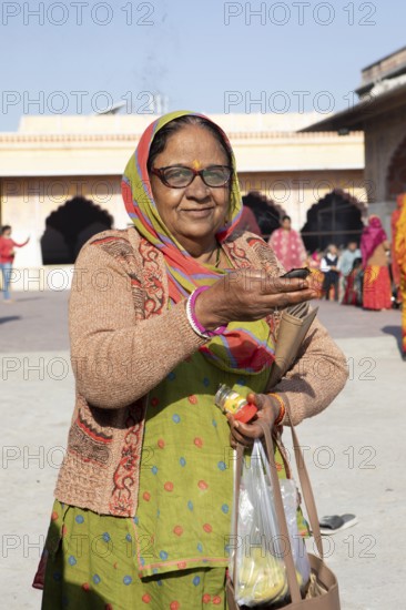 Indian woman holding a tea light at the Govind Dev Ji Hindu temple in the old city, Jaipur, Rajasthan, India