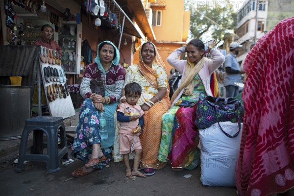Indian child and Indian woman in colourful saris laughing out of focus in the old town, Jaipur, Rajasthan, India
