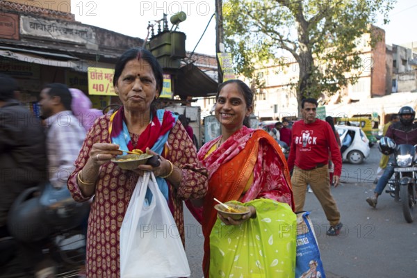 Indian woman eating kachori or dumplings filled with beans in the old city centre, Jaipur, Rajasthan, India
