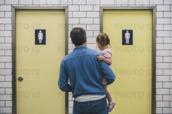 Father with young daughter hesitating in front of men's and women's restroom doors. Concept of gendered public toilet challenges for parents. Generative ai, AI generated