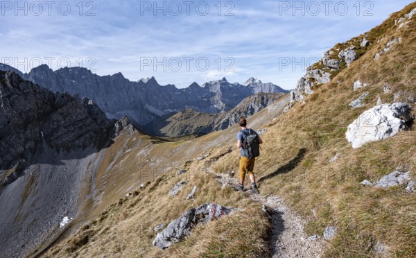Mountaineers on a hiking trail at the Gamsjoch, picturesque mountain landscape in autumn, view of the rocky mountain ridge of the Hinterautal-Vomper chain, Rißtal in the Eng, Karwendel, Tyrol, Austria