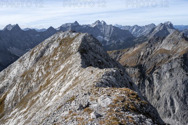 Mountain panorama, mountaineer on the ridge of the Gamsjoch, transition to the main summit of the Gamsjoch, behind western summit with summit cross, behind mountain ridge of the Hinterautal-Vomper chain, in autumn, Rißtal in the Eng, Karwendel, Tyrol, Austria