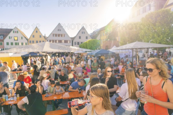 Visitors relax at tables in sunny weather, surrounded by historic house facades, 950 years Weil der Stadt ceremony, Böblingen district, Germany