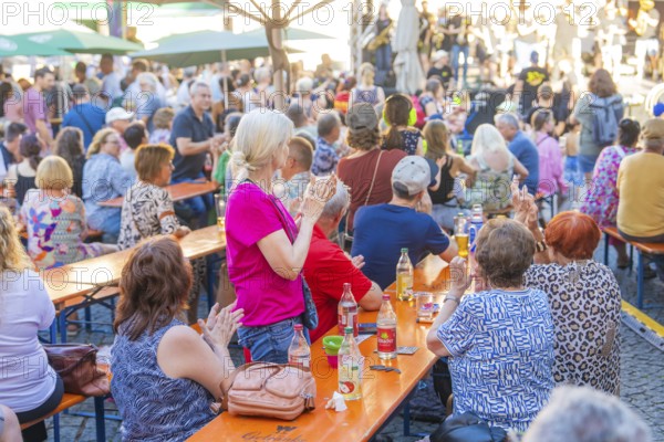 People sitting at long tables at a party, applauding and enjoying drinks, 950 years Weil der Stadt ceremony, Böblingen district, Germany