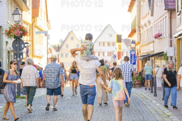 Families and pedestrians stroll through a lively old town street in sunny weather, 950 years of Weil der Stadt celebrations, Böblingen district, Germany