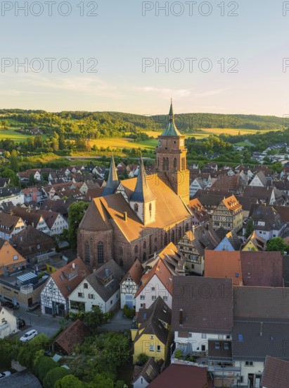 Historic church in the middle of a town with hills in the background in warm evening light, 950 years Weil der Stadt ceremony, Böblingen district, Germany