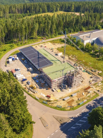 Building complex under construction near the forest, with solar panels and a crane visible, new fire station, Oberhaugstett, Calw district, Germany
