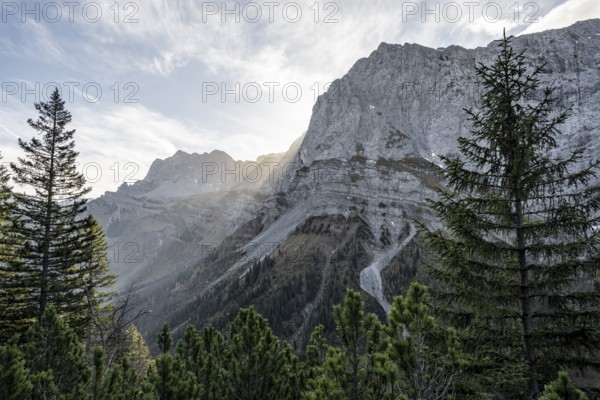 Sunbeams fall over a rocky mountain ridge, Mountain landscape in autumn in the morning light, Rocky mountain peak of the Spritzkarspitze, Rißtal in the Eng, Karwendel, Tyrol, Austria