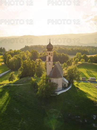 Church in the middle of a summer landscape with bright sunshine and lush green fields