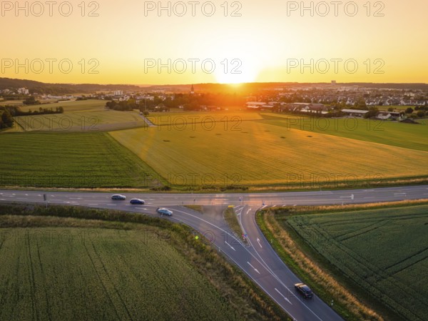 Fields and streets under a golden sunset, quiet evening atmosphere with traffic, Renningen, Germany
