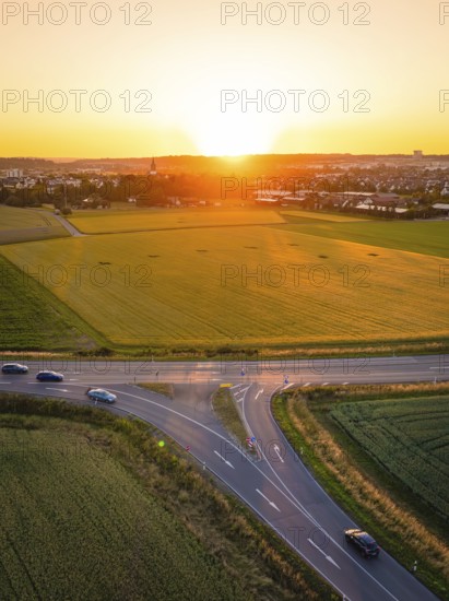 Crossroads and fields at sunset, cars on the road, peaceful atmosphere, Renningen, Germany