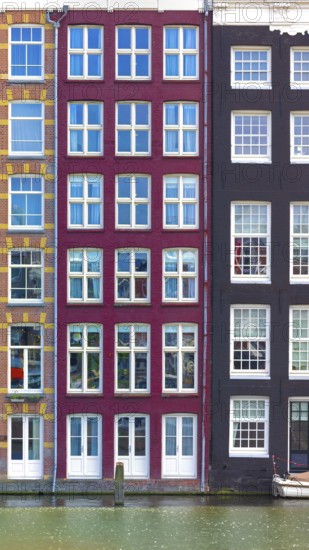 Holland, Amsterdam Damrak canal houses with scenic bridges in historic center, UNESCO Heritage site