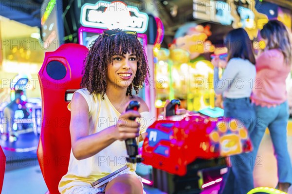 Young woman having fun playing a racing simulator in an amusement arcade with her friends in the background
