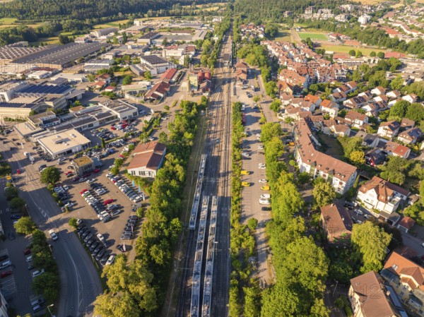 Metropolitan scene with railway tracks and factories, diverse buildings in summery surroundings, Weil der Stadt railway station, Böblingen district, Germany