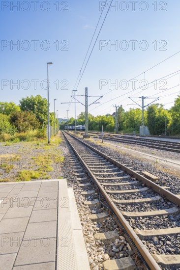 View along the railway tracks in a green environment, clear sky, feeling of travelling, Weil der Stadt railway station, Böblingen district, Germany