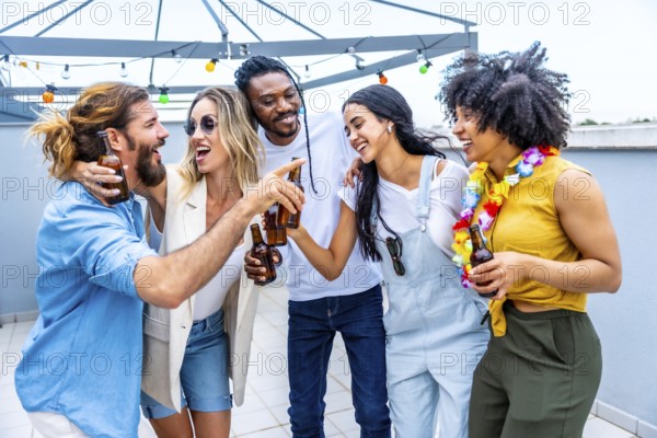 Cheerful multi ethnic friends enjoying drinks at a rooftop party, celebrating their friendship with toasts and laughter