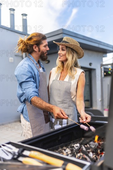 Happy couple enjoying a sunny summer day, grilling marshmallows on a rooftop barbecue, sharing laughter and creating joyful memories together