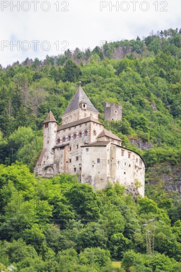 Medieval castle on a wooded hill with towers and walls, Dolomites, South Tyrol, Italy