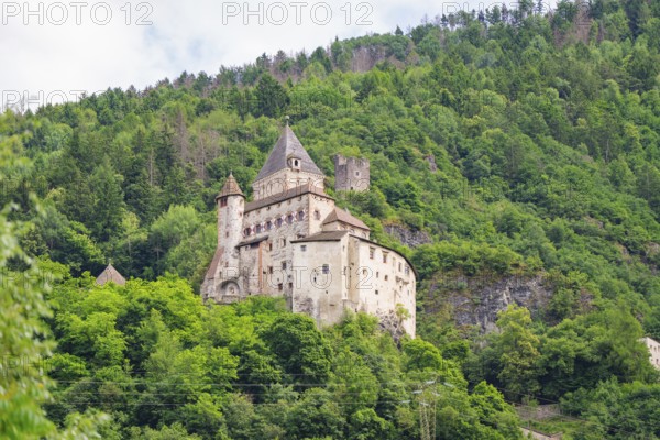 Historic castle complex on a wooded hill with defence towers and walls, Dolomites, South Tyrol, Italy
