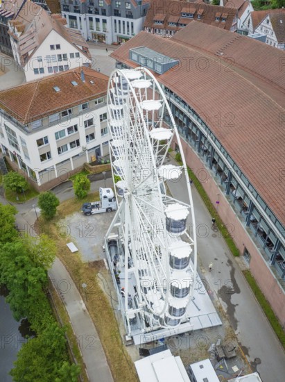 Close-up of a white Ferris wheel in an urban area with several buildings and a river, Ferris wheel construction, Calw, Black Forest, Germany