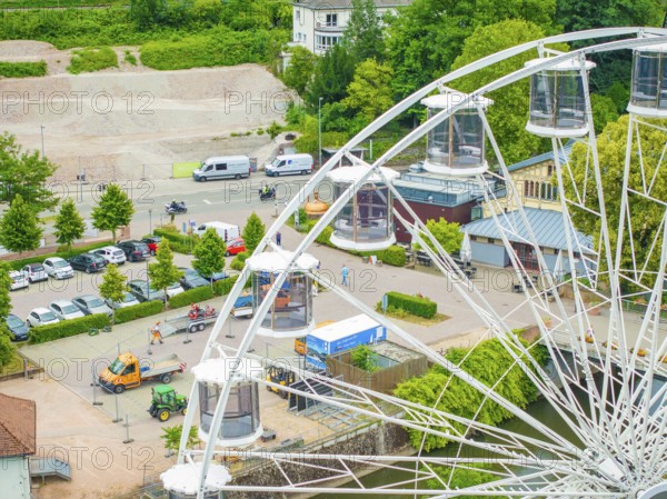 Ferris wheel with visible cabins, parked cars and green surroundings, construction of Ferris wheel, Calw, Black Forest, Germany