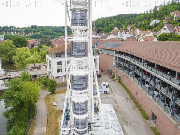 Narrow street view next to a high Ferris wheel in an urban environment, construction of a Ferris wheel, Calw, Black Forest, Germany