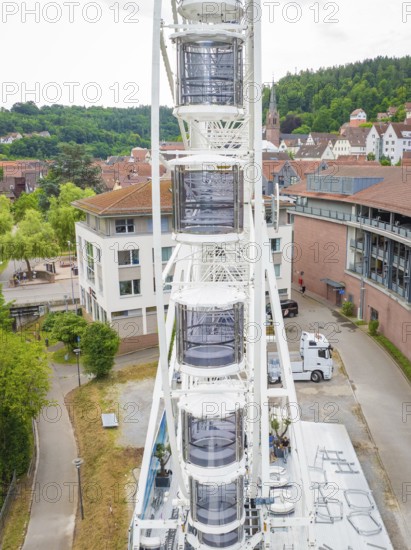 Ferris wheel set up right next to modern buildings in the town centre, Ferris wheel construction, Calw, Black Forest, Germany