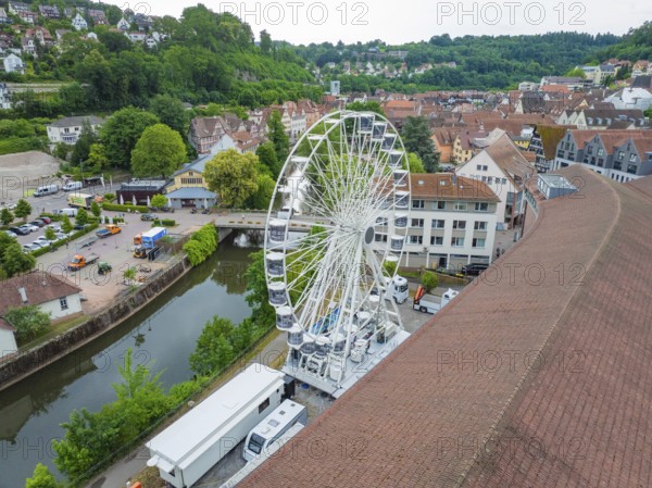 Aerial view of a Ferris wheel in the middle of a town in summer weather and wooded surroundings, construction of a Ferris wheel, Calw, Black Forest, Germany
