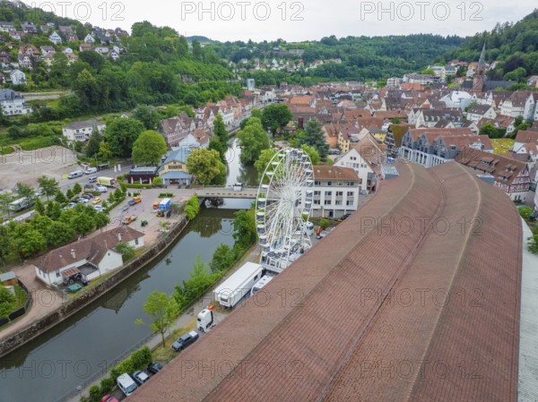 Aerial view of a town with a Ferris wheel in the centre, surrounded by densely built-up houses and a river, construction of a Ferris wheel, Calw, Black Forest, Germany