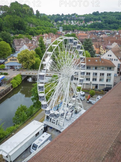A large Ferris wheel towers over the city centre, surrounded by the river and green landscape, Ferris wheel construction, Calw, Black Forest, Germany