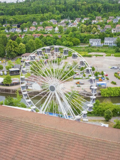 Ferris wheel in a natural environment with green landscape and city view from above, construction of Ferris wheel, Calw, Black Forest, Germany
