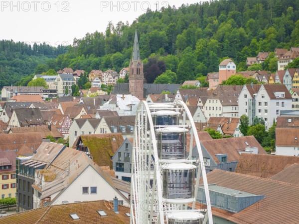 Ferris wheel in the foreground of a town view with church and wooded hills, Ferris wheel construction, Calw, Black Forest, Germany
