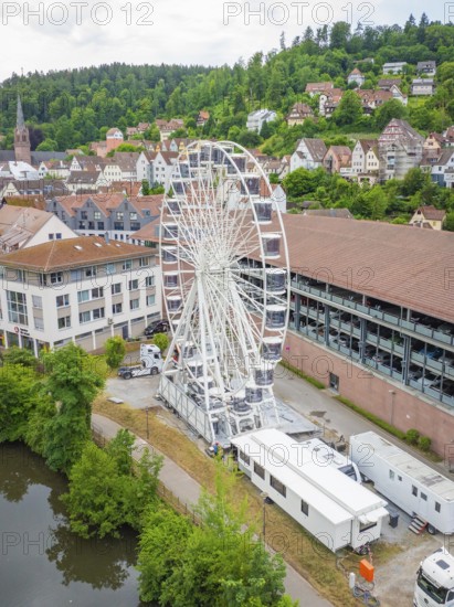 The Ferris wheel stands prominently in an urban landscape with a river and wooded hills, Ferris wheel construction, Calw, Black Forest, Germany