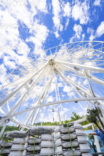 Partially erected Ferris wheel in front of a clear blue sky with cloud formations, Ferris wheel construction for the 950th anniversary of the city of Calw, Black Forest, Germany