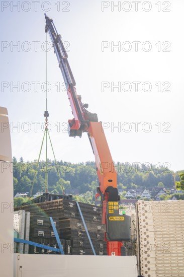 A crane lifts a heavy load in front of a cloudy sky, Ferris wheel construction for the 950th anniversary of the city of Calw, Black Forest, Germany