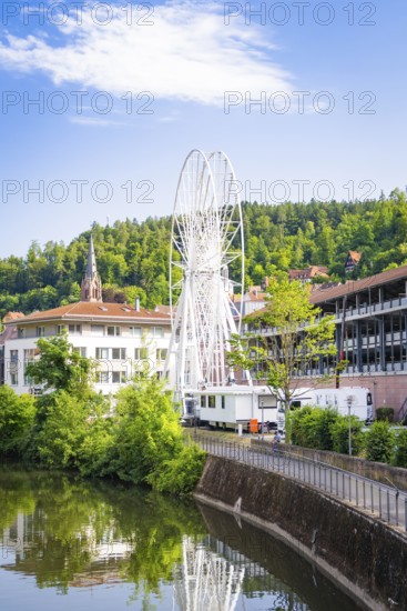 Ferris wheel in an urban environment with church and river in the background, Ferris wheel construction for the 950th anniversary of the town of Calw, Black Forest, Germany