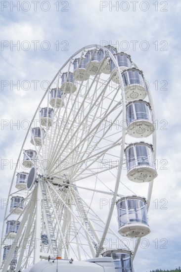 Ferris wheel with numerous gondolas in front of a cloudy sky, Ferris wheel construction for the 950th anniversary of the city of Calw, Black Forest, Germany