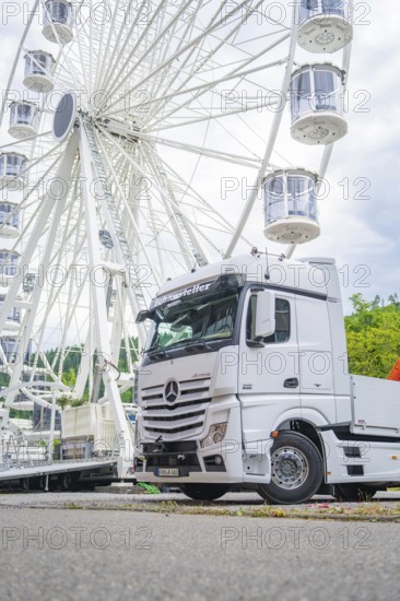 Large Ferris wheel in the background of a parked white lorry on a cloudy day, Ferris wheel construction for the 950th anniversary of the town of Calw, Black Forest, Germany