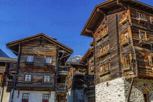 Old wooden houses in log construction, decorated with flowers, historic village centre, Grimentz, Val d'Anniviers, Valais Alps, Canton Valais, Switzerland